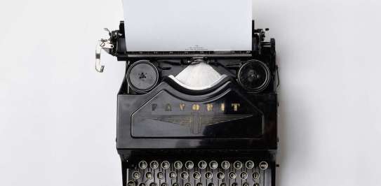 An old fashioned typewriter sits on a desk