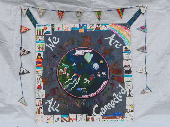 Artwork created by pupils at Marwood Infant CE Primary School for the Letters for Creation Project. The image showcase earth, with a chain of people holding hands around the outside. The artwork has text on it reading: "we are all connected". 