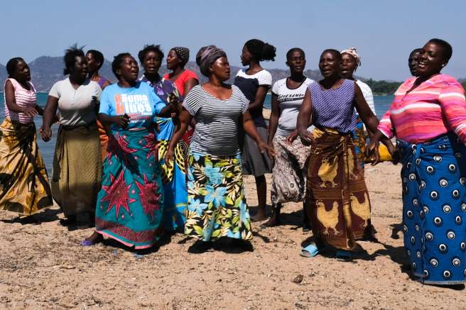 Women participating in the breaking the barriers project dance on the shore