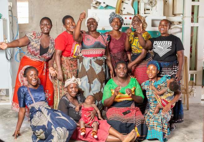 Mable Nyrienda, cooperative secretary (far left in red) and Kondwani Kaluwa (in blue beneath her) and the Lusako cooperative members. 