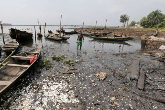 A man stood in the middle of a polluted river