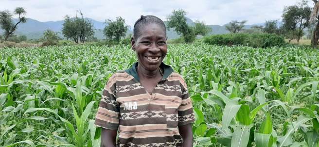 Ethiopian woman smiling admist her field of crops