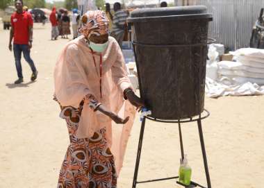 Bintu washes her hands in a displacement camp in Nigeria 